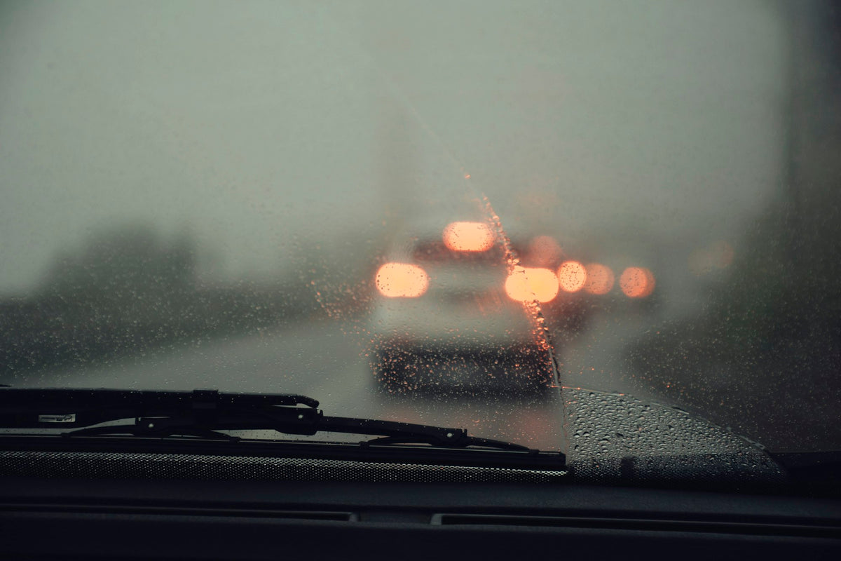 Car window covered in water droplets